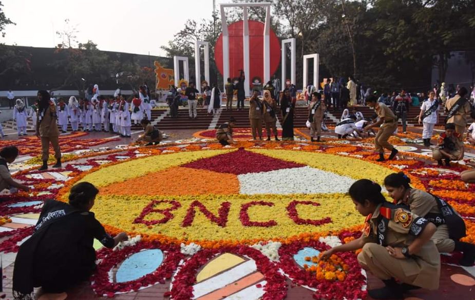 একুশে ফেব্রুয়ারির সকালে ফুলে ফুলে ভরে গেছে স্মৃতির মিনার, সেই ফুল সাজিয়ে রাখছেন সেচ্ছাসেবকেরা 